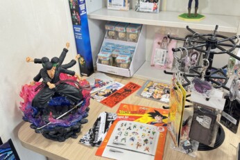 Présentation de divers goodies et accessoires inspirés de mangas, incluant des chapeaux, sacs, figurines et objets de collection, dans une boutique à Cahors.