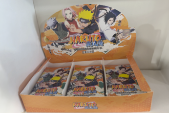 Booster de cartes Naruto exposé dans une étagère de la boutique à Cahors, mettant en avant les personnages emblématiques de l'anime.